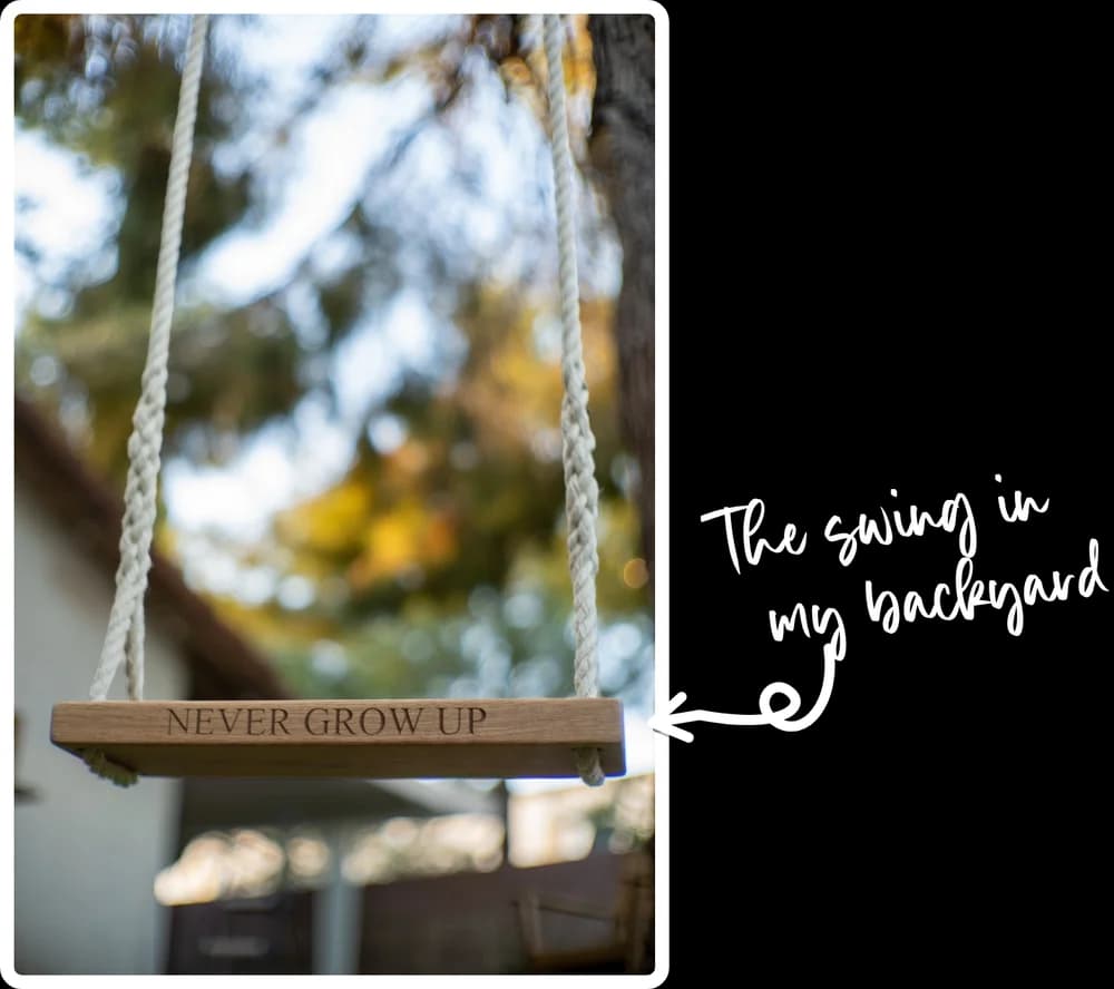 An empty wooden rope swing engraved “Never grow up” hanging beneath autumn trees, with “The swing in my backyard” handwritten beside it and an arrow pointing to the seat