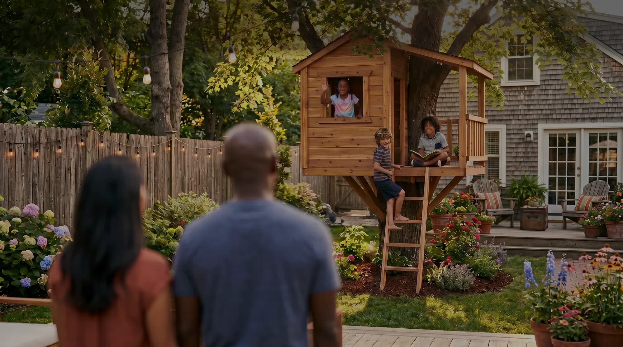 Parents watching kids play in a backyard treehouse